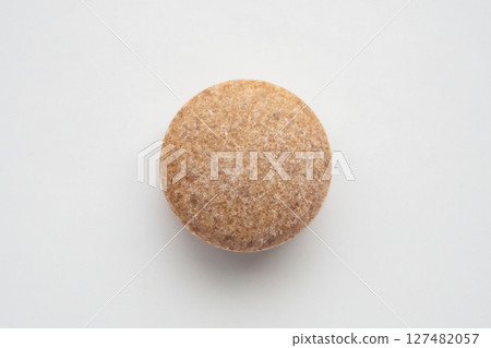 Brown herbal pill tablet on white background 127482057