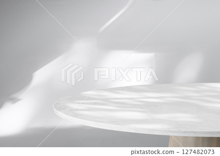 Round marble table top with abstract shadow drop on white wall background for mockup product display 127482073