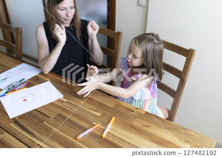 Speech therapist helping young girl with pronunciation and communication skills 127482192