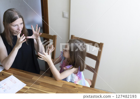 Teacher and student communicating using sign language at home 127482193