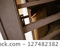 Close-up of a dark textured metal gate hinge mechanism 127482382