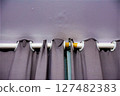 Curtain rod with gray curtains attached to a light purple wall 127482383