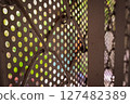 Perforated metal sheet with colorful blurred light background 127482389