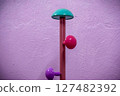 Colorful modern coat rack with turquoise, pink, and purple knobs 127482392