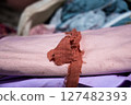 Close-up of stacked colorful fabrics with a frayed textile strip 127482393
