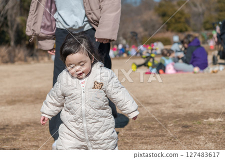 [一名一歲兒童和他的母親在相模原市麻溝公園的草地上玩耍] 127483617