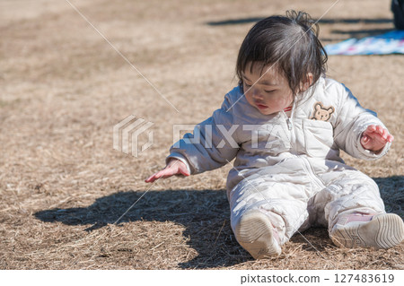 [相模原市立麻溝公園，一位一歲兒童坐在草地上玩耍] 127483619