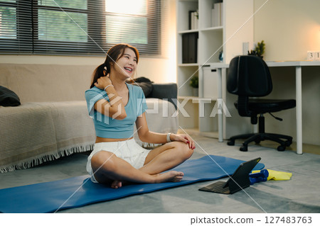 Relaxed woman cooling down after exercise on yoga mat. Wellness concept Relaxed woman cooling down after exercise on yoga mat. Wellness concept 127483763