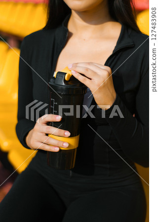 Woman Holding Black And Yellow Shaker Woman Holding Black And Yellow Shaker 127483908