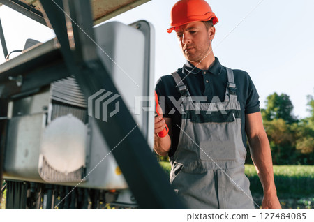 Checking the temperature by thermal imager. Man is doing operating and maintenance in solar power plant Checking the temperature by thermal imager. Man is doing operating and maintenance in solar power plant 127484085