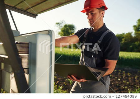 Maintenance by using laptop. Man is doing operating solar power plant 127484089