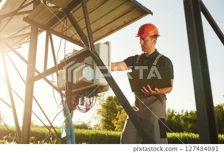 Maintenance by using laptop. Man is doing operating solar power plant 127484091