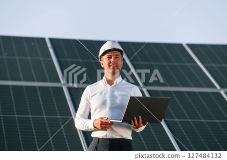 Modern laptop is in hands. Man is doing operating and maintenance in solar power plant Modern laptop is in hands. Man is doing operating and maintenance in solar power plant 127484132