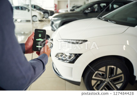 Information of charging process. Close up view of man that is with electrical car Information of charging process. Close up view of man that is with electrical car 127484428