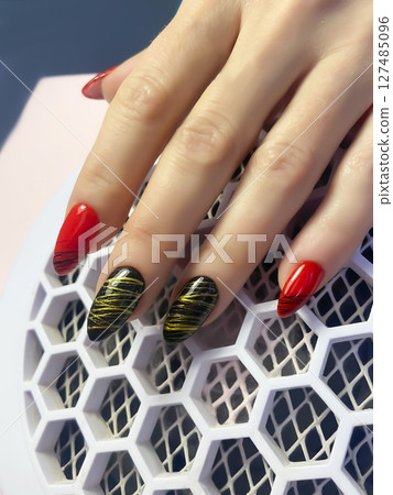 Nail extensions, manicure, nail correction, hands in the foreground gel polishes 127485096
