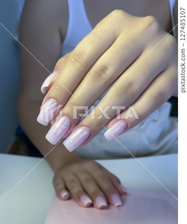 Nail extensions, manicure, nail correction, hands in the foreground gel polishes 127485107