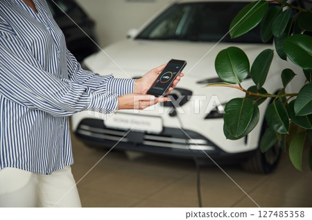 Conception of green energy. Smartphone with charging process data. Close up view of woman Conception of green energy. Smartphone with charging process data. Close up view of woman 127485358