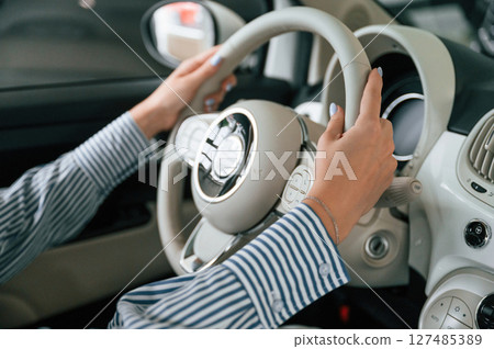 Driving the automobile. Close up view of woman that is with electric car 127485389
