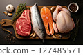 Assortment of fresh raw beef steak, whole fish, salmon, and chicken on a wooden board 127485571