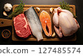 Raw beef steak, whole fish, salmon, and chicken on a wooden board with herbs and spices. 127485574