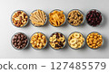 Assortment of various snacks in glass bowls from a top down perspective on a light background. 127485579