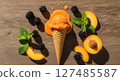 Melting orange ice cream cone with fresh peaches, blackberries, and mint leaves on wood 127485587
