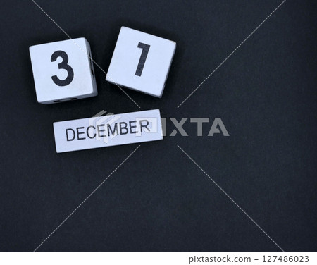 Wooden calendar, December 31st, New Year's Eve on black background 127486023