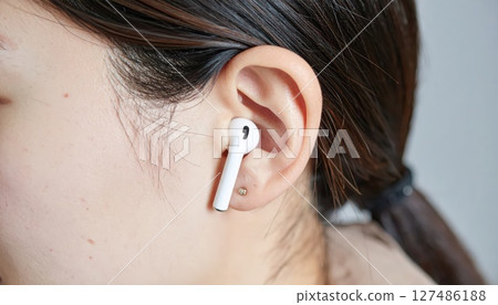 AI Image: Close-up of a woman wearing Bluetooth earphones 127486188