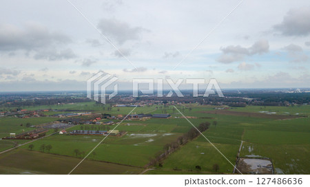 An aerial view of tranquil countryside with vast green fields and charming villages An aerial view of tranquil countryside with vast green fields and charming villages 127486636