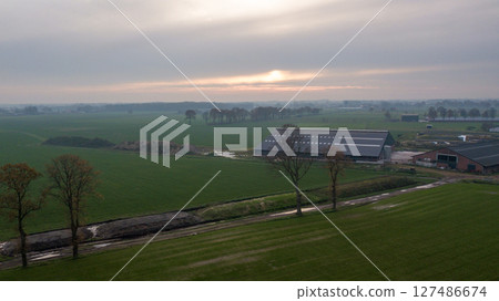 The Serene Landscape at Dawn Beautiful Fields and Charming Farmhouses in Natures Splendor 127486674