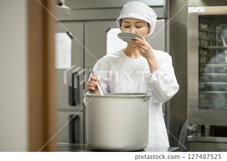 食品開發部的一位女士在廚房品嚐湯。 127487525