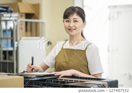 一位中年婦女在超市後院工作的畫像 127487552