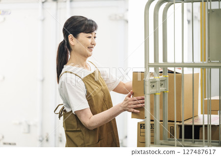 一位 50 多歲女性在物流倉庫工作的肖像 一位 50 多歲女性在物流倉庫工作的肖像 127487617