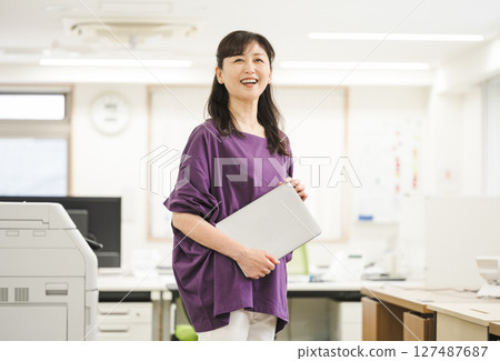 Middle-aged woman working in an office Middle-aged woman working in an office 127487687