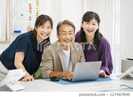 Middle-aged and senior male and female business people working in an office 127487690