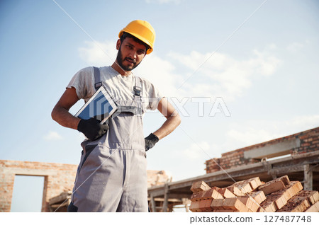 Manager with digital tablet. Handsome Indian man is on the construction site Manager with digital tablet. Handsome Indian man is on the construction site 127487748