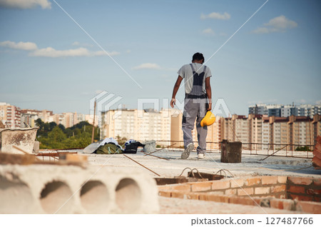 Rear view. Handsome Indian man is on the construction site Rear view. Handsome Indian man is on the construction site 127487766