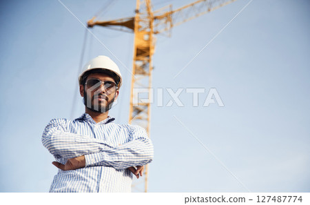 Manager in sunglasses. Handsome Indian man is on the construction site Manager in sunglasses. Handsome Indian man is on the construction site 127487774