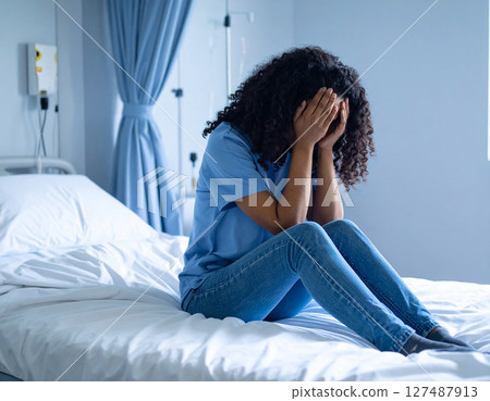 Woman holding her head in bed 127487913