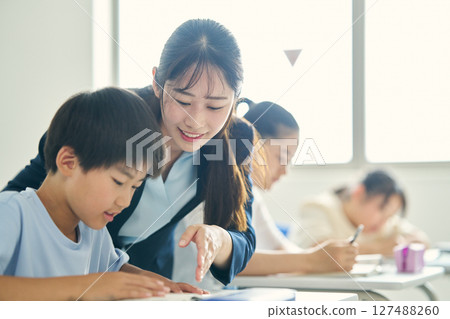 A teacher teaching children at a cram school 127488260