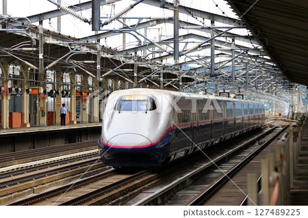 Tohoku Shinkansen E2 series train passing Fukushima Station at high speed 127489225