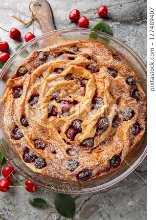 Cherry Soufra phyllo tart with vanilla custard cream and powdered sugar close-up in glass bowl. vertical top view 127489407