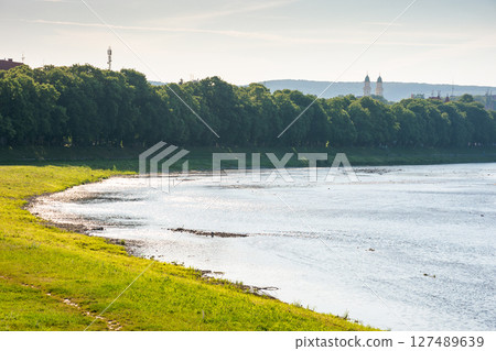 embankment of the river uzh in morning light. wonderful urban landscape in summer. linden alley on the left shore. carpathian travel destination embankment of the river uzh in morning light. wonderful urban landscape in summer. linden alley on the left shore. carpathian travel destination 127489639