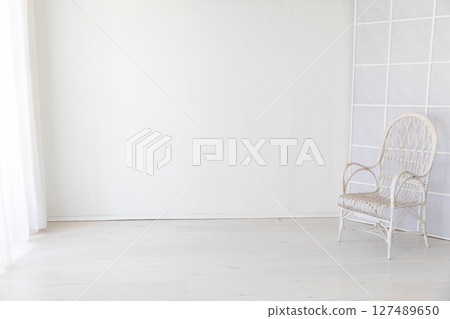 white vintage armchair in the interior of a room with a window white vintage armchair in the interior of a room with a window 127489650