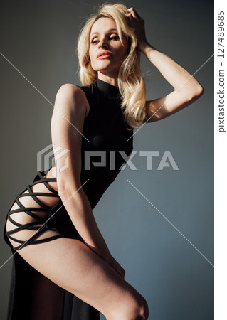 Slim Fashion Woman In Black Evening Dress By Window Slim Fashion Woman In Black Evening Dress By Window 127489685