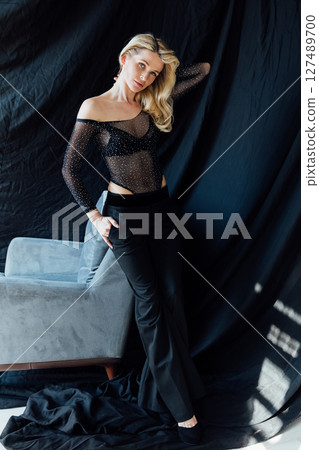 Beautiful fashionable blonde in a black evening suit Beautiful fashionable blonde in a black evening suit 127489700