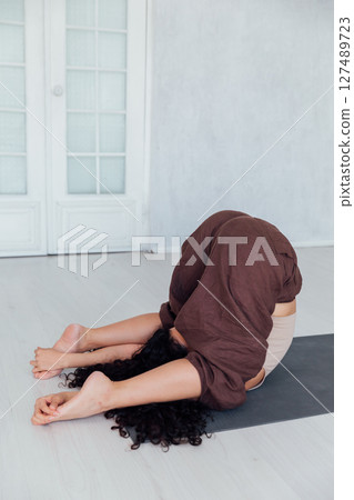 Fitness Woman Brunette Doing Gymnastics Yoga Asana On The Floor 127489723