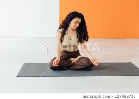 sports woman brunette doing gymnastics yoga asana in the gym 127489733