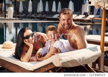 Conception of vacation. Happy family of father, mother and son are in the pool 127490425