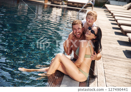 Cheerful people are sitting. Happy family of father, mother and son are in the pool Cheerful people are sitting. Happy family of father, mother and son are in the pool 127490441